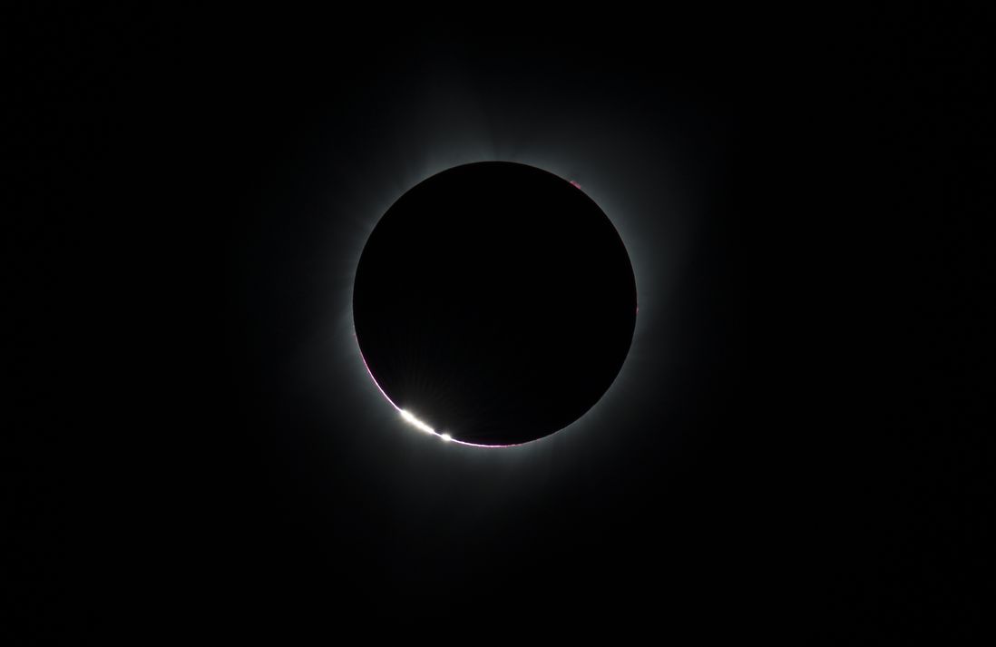 The Sun’s corona, only visible during the total eclipse, is shown as a crown of white flares from the surface during a total solar eclipse on Monday, August 21, 2017 from onboard a NASA Gulfstream III aircraft flying 25,000 feet above the Oregon coast. The red spots are called Bailey's beads.